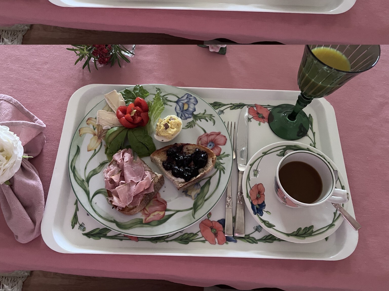 An overhead view of a coordinated floral tray, teacup, and meal.