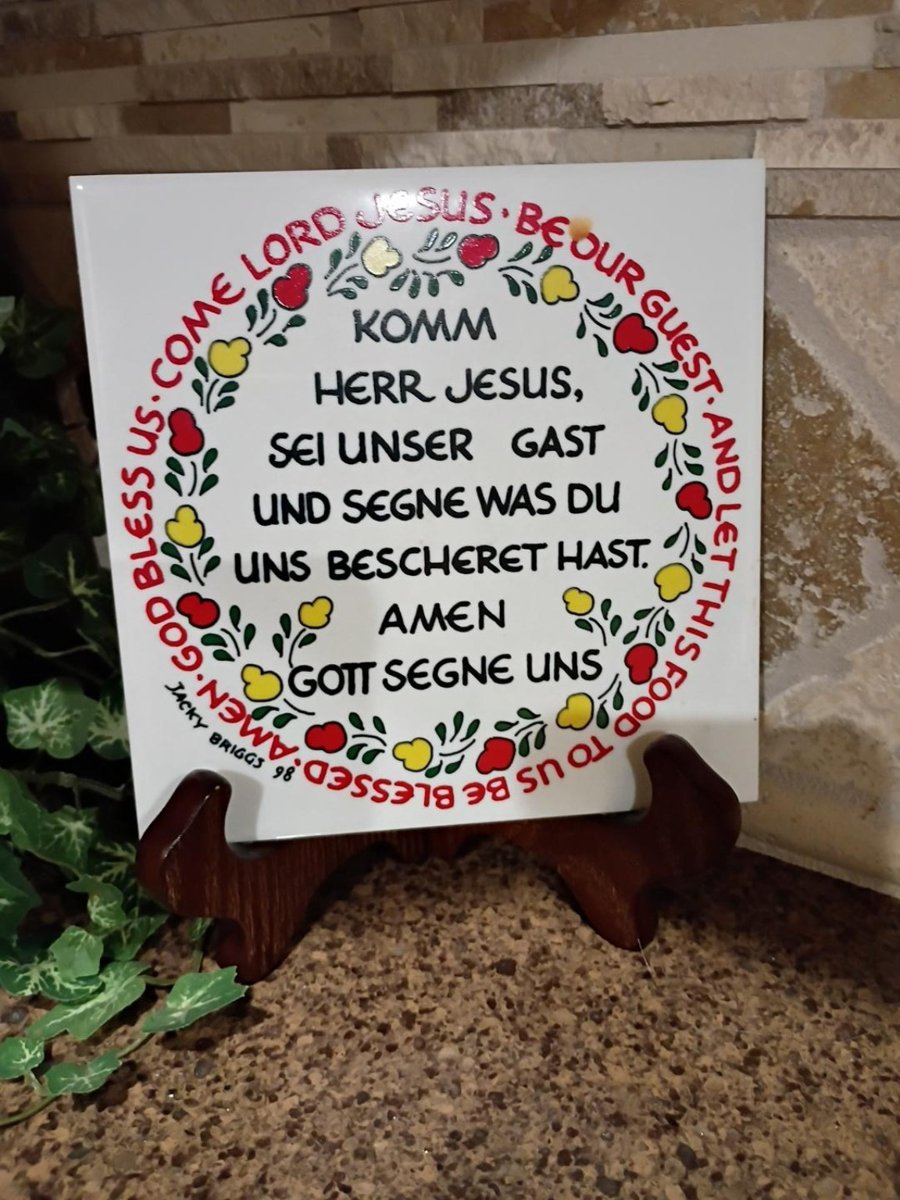 A family prayer plaque with German text in the center and English text around the border.